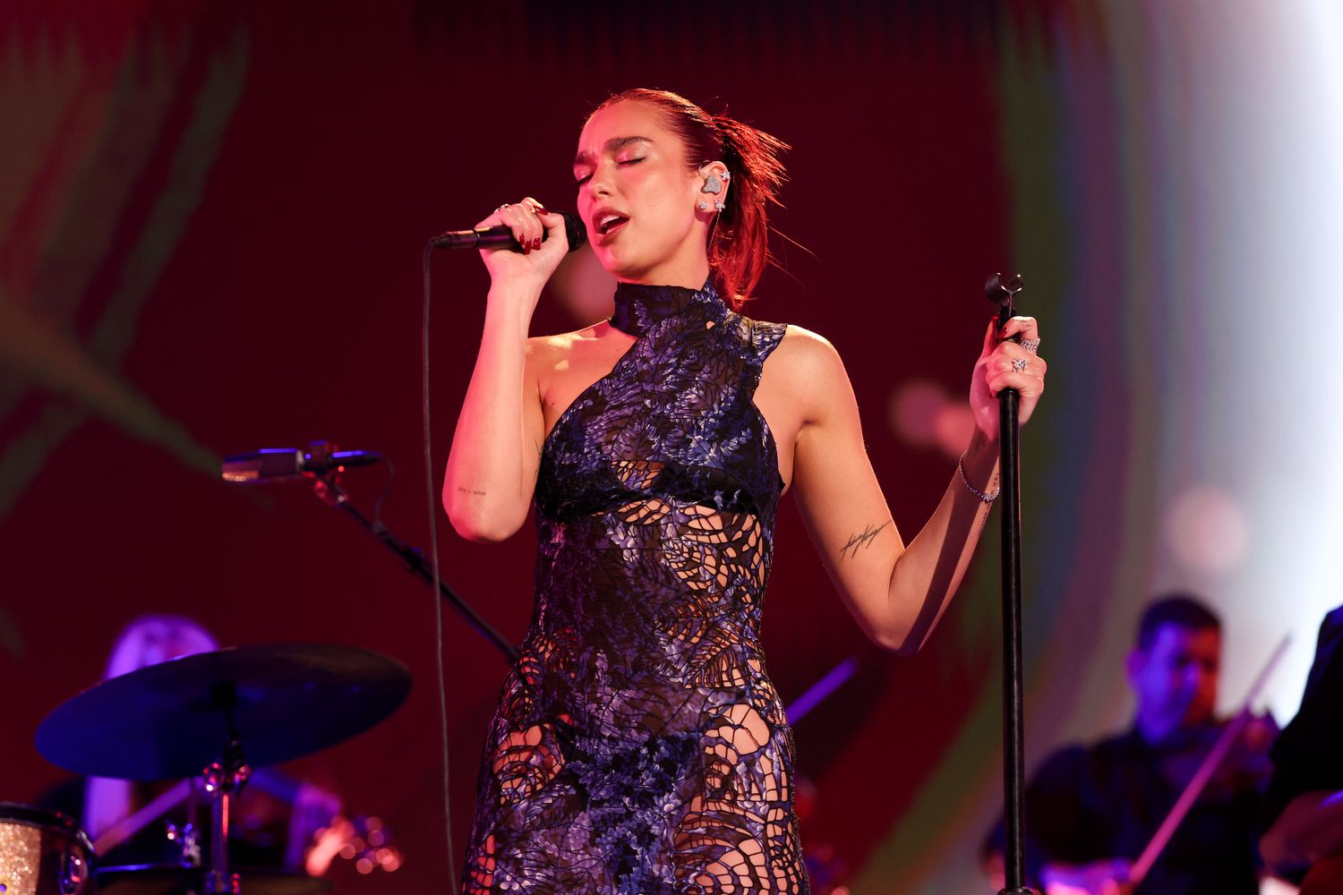 Dua Lipa wearing a blue dress performing at the American Country Music Awards.